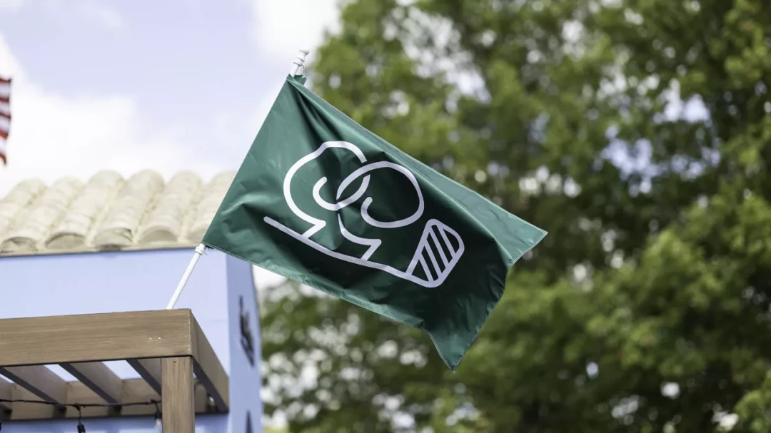 Green flag with the Good Good logo flying at the golf tournament in Texas.
